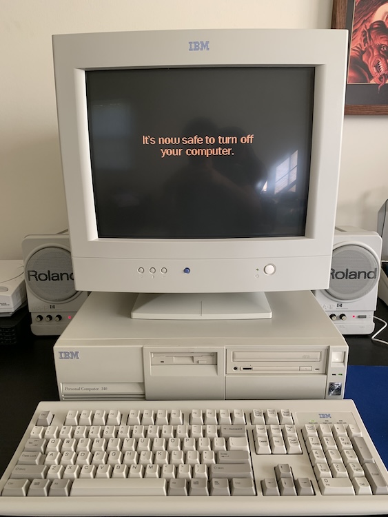 Photograph of a large PC from the early 90s with a big CRT screen displaying the text: It is now safe to turn off your computer.