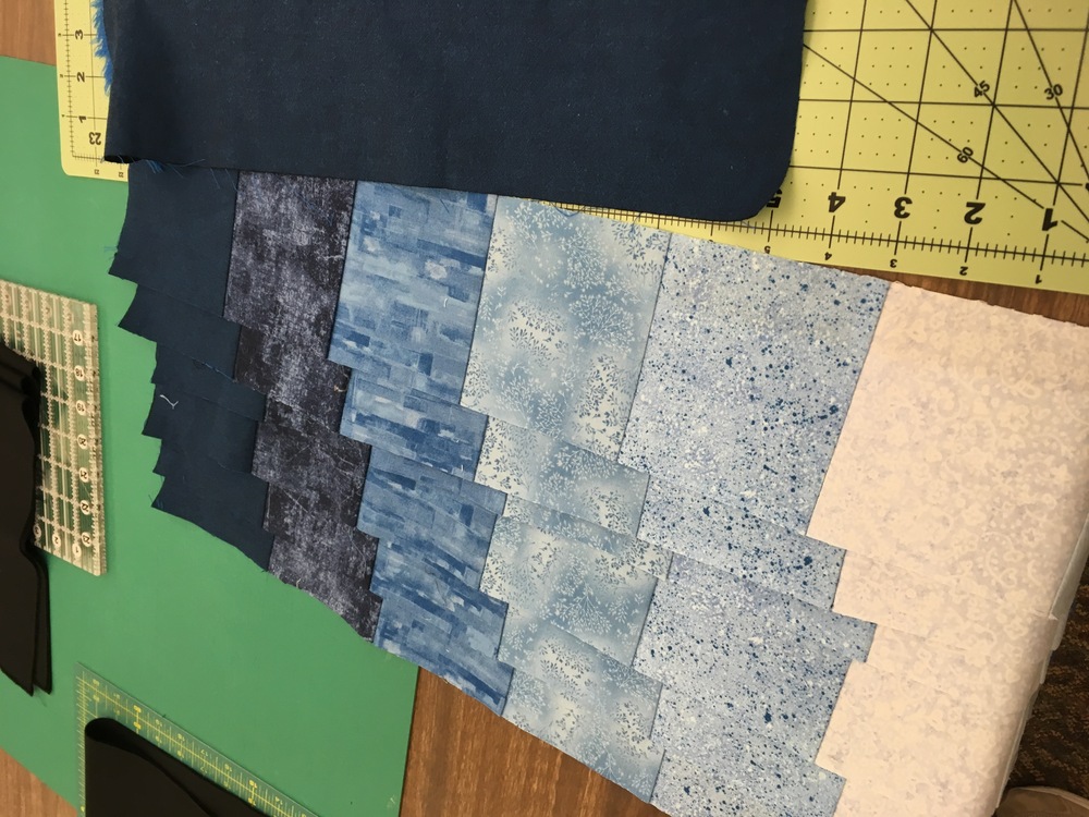 A set of identical strips that look like they’re pieced from big pixels of the quilt’s fabrics