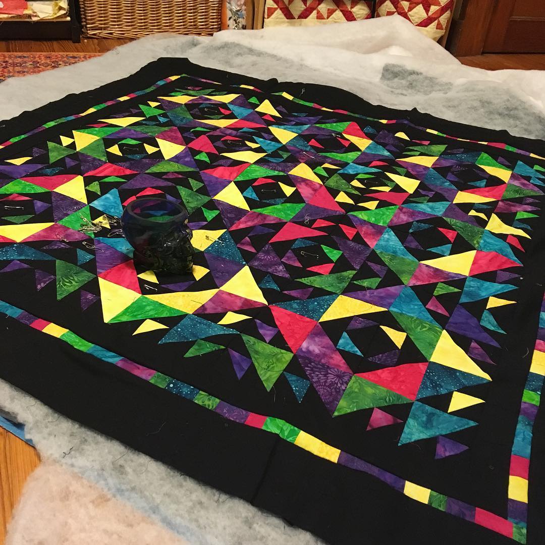 A view of the quilt lying on the floor with visible batting.